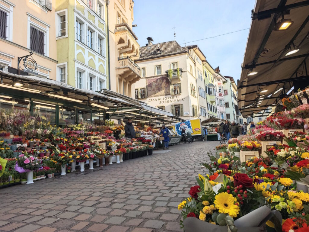 Bozen Sehenswürdigkeiten - der Obstmarkt mit den vielen Ständen vor den bunten Hausfassaden